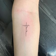 a small cross tattoo on the leg