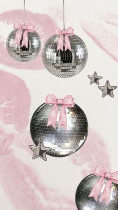 three shiny disco balls with pink bows hanging from the ceiling and stars on the wall