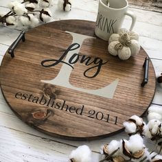 a round wooden sign that says long established 2011 with cotton floss next to it