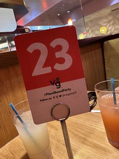 there is a sign that says 23 vg on the table next to two drinks