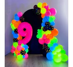 an arch made out of balloons with the number nine on it