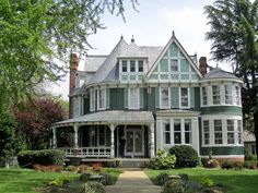 a large green and white house with lots of windows