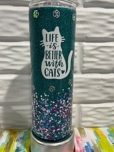 a green glitter tumbler with a cat on it's side and the words life is better with cats