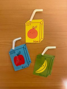 two paper bags with apples, banana and orange on them are sitting on a table