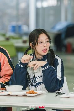 two people sitting at a table eating food