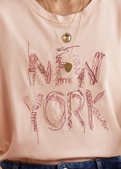 a woman wearing a pink new york t - shirt with writing on the front and back