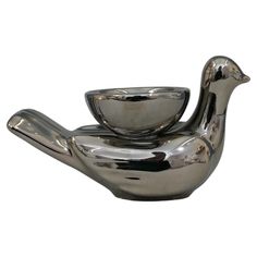 a silver bird shaped bowl sitting on top of a saucer