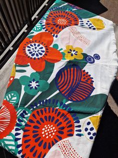 an outdoor blanket with colorful flowers on it