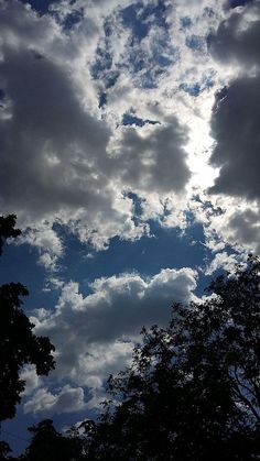 the sky is filled with clouds and trees