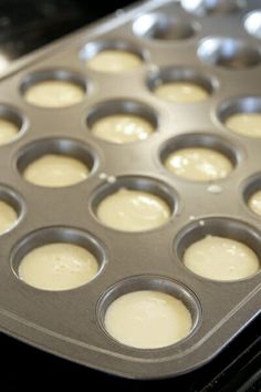 a muffin tin filled with batter sitting on top of an oven