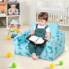 a small child sitting in a blue chair with a book on it's lap