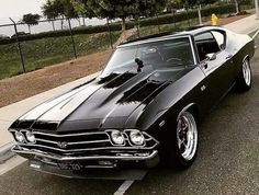 a black muscle car parked in a parking lot