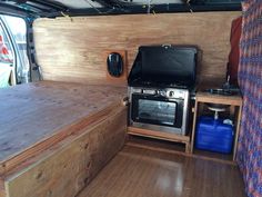 the inside of a camper with a bed and stove