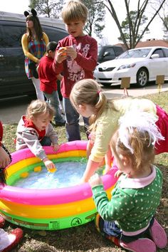 children playing in an inflatable pool on the grass