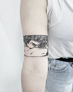 a woman's arm with a black and white tattoo design on the left forearm