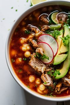 A bowl of pozole topped with avocado slices, radish, and cilantro. Mexican Food Authentic Mexico, Authentic Mexican Posole Recipe, Mexican Hangover Soup, Green Pozole Recipe Pork Mexican Posole, Pazole Soup Beef, Pisola Soup, Posole Instant Pot Recipe, Mexican Soups Pozole, Mexican Style Soup