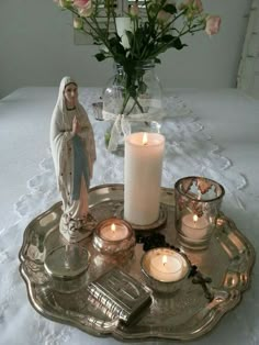 a tray with candles and a statue on it