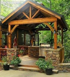 a covered patio with an outdoor kitchen and grilling area in the middle of it