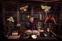 a woman sitting at a desk with an open book in front of her, surrounded by bookshelves and lamps