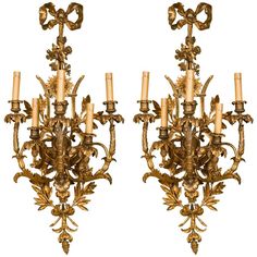 a pair of gilded wall sconces with candles in the form of flowers and leaves