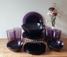 a table topped with purple dishes and glasses