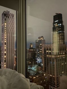 a view of the city at night from a hotel room window