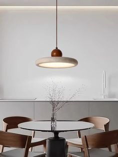 a dining room table with chairs and a round light fixture hanging over it's head