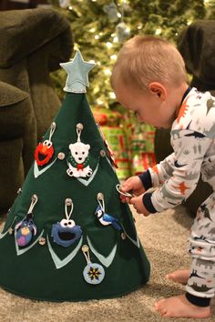 a young boy decorating a christmas tree with ornaments on the top and bottom part