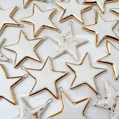 several gold and white star shaped ornaments sitting on top of each other in the shape of stars