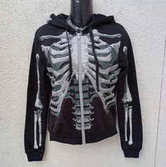 The Black & Bone Hoodie For Adults Gives New Meaning To The Term "The Walking Dead!" This Long-Sleeve Black Sweatshirt Features A Detailed X-Ray Skeleton Print On The Front And Back, Including Skull Profiles On Either Side Of The Hood. Rock This Spooky Look On Halloween Or Every Day Brand Black And Bone Item Skeleton Hoodie Size One Size Fits Most Fits Like A Small Measurements Pictured Not Responsible For Fit Or Size Condition New With Tags And Packaging Items Can Contain Unseen Flaws Please Se Rib Cage Jacket, House Scary, Skeleton Clothes, Skeleton Hoodie, Ribbed Jacket, Coats Black, Halloween Costume Party, Creepy Horror, Scary Creepy