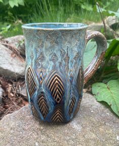 a blue mug sitting on top of a rock