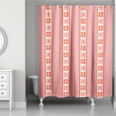 a bathroom with a pink shower curtain next to a white dresser and mirror on the wall