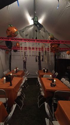 the inside of a tent with tables and chairs set up for halloween dinnereons