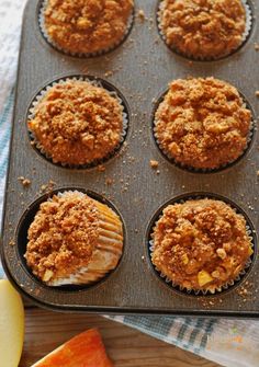 muffins with crumbs and apple slices in a pan on a table