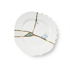 a white plate with blue flowers on it and two gold forks sticking out of the side