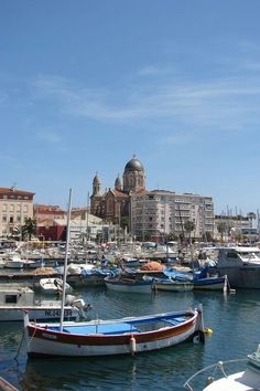 many boats are docked in the water near some buildings and other large buildings with domes on them