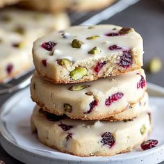 three cookies stacked on top of each other with white icing and cranberries