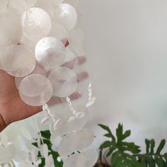 a hand is holding some white glass beads