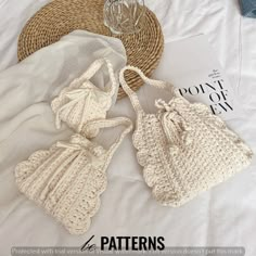 two crocheted bags sitting on top of a bed