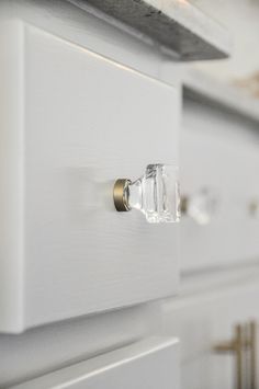 a close up view of the handles on a white cabinet