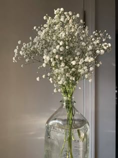 a glass vase filled with white flowers on top of a table