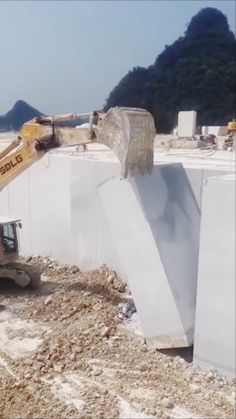 an excavator is working on the side of a building that's under construction