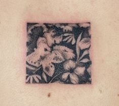 a black and white photo of flowers on the back of a man's chest