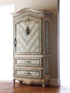 an old fashioned armoire with chevroned drawers