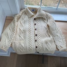 Cream Color Fisherman Cable-Knit Button-Down Cardigan Sweater With Collar And Front Patch Pockets. Raglan Sleeves. Thick, Heavyweight, And Very Warm. Pure New Wool, Itchy Material. It’s Unused And In Pristine Condition. Has A Slight Vintage Odor Due To Its Age. One Size - Could Fit Up To An Xxl - Please Check Measurements Below To Determine Fit. Approx Flat- Pit To Pit 24” Length 27.5” Sleeve Length 30” Classic Beige Sweater With Buttons, White Cable Knit Button-up Outerwear, White Knitted Button-up Outerwear, Classic Sweater Coat With Buttons, Classic Button-up Sweater With Buttons, White Cable Knit Long Sleeve Polo Sweater, Classic Long-sleeved Sweater Coat With Buttons, Classic Long Sleeve Sweater Coat With Buttons, Classic Long Sleeve Winter White Cardigan