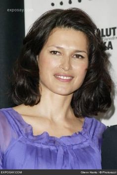 a woman in a purple dress smiling for the camera