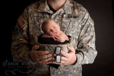 a soldier holding a sleeping baby in his arms