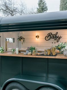 an outdoor bar with flowers and candles on the counter, next to a green truck