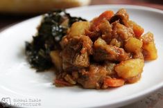 a white plate topped with meat and vegetables