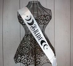 a white ribbon with the word bride on it sitting next to a mannequin